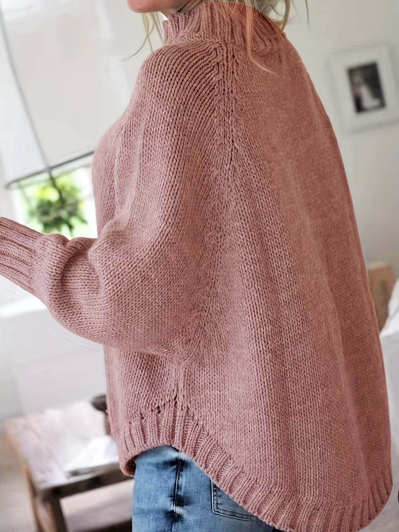 Kvinde iført sweater med høj hals, markante snoninger og afslappet pasform._7