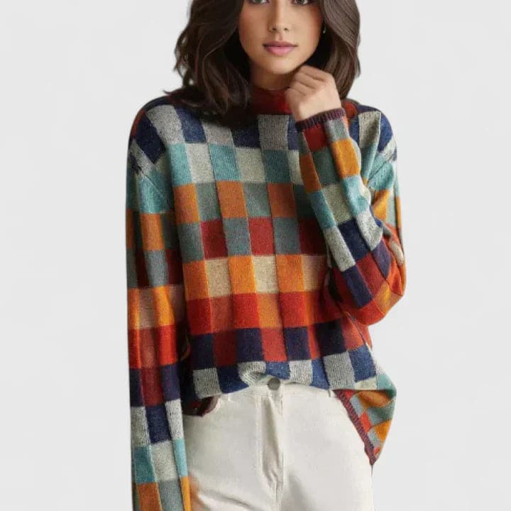 Kvinde iført sweater med farverigt ternmønster i blå, orange, rød og grøn nuancer, stylet med hvide bukser_0