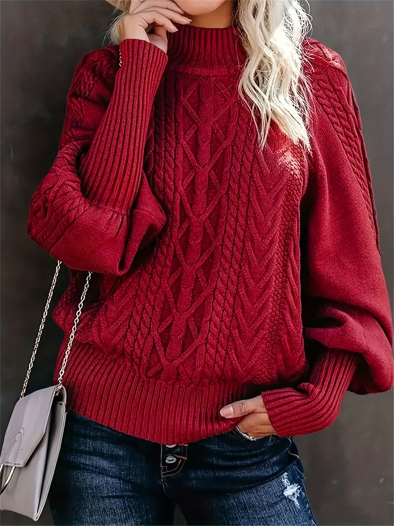 Kvinde iført sweater med højhalset krave og snoninger, stylet med jeans og skulderrem_3