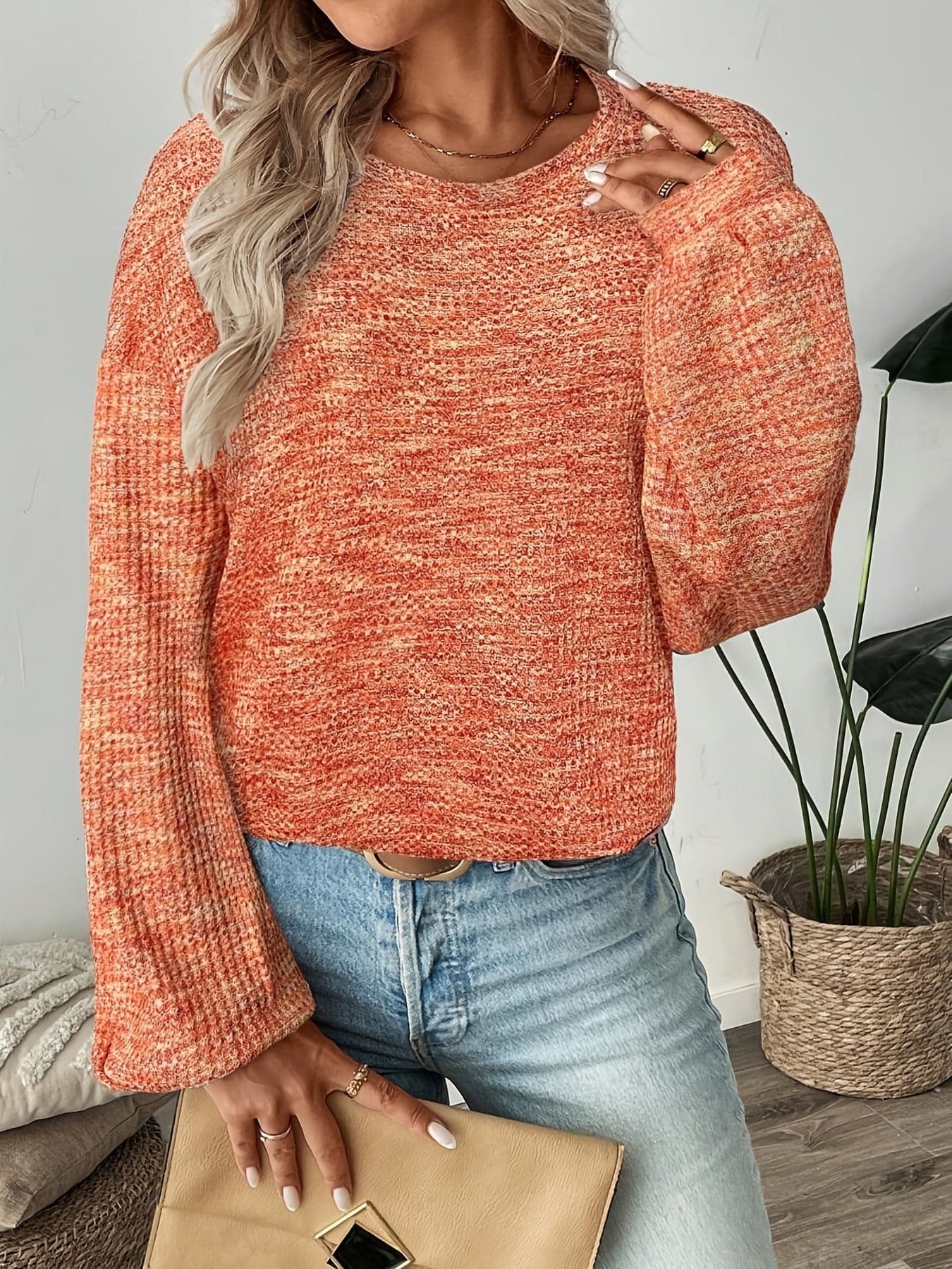 Model iført en rødorange sweater i vaffelstrik med afslappet pasform og lange ærmer, set forfra mod lys baggrund._3