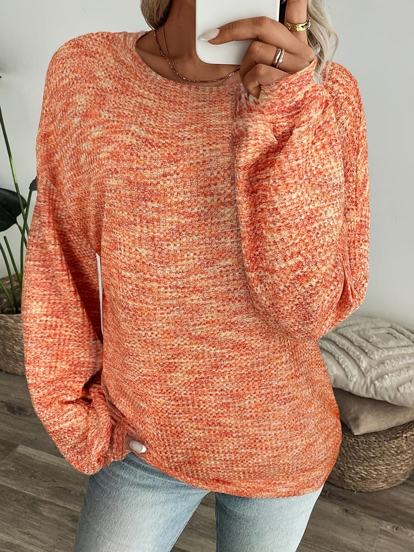 Model iført en rødorange sweater i vaffelstrik med afslappet pasform og lange ærmer, set forfra mod lys baggrund._5