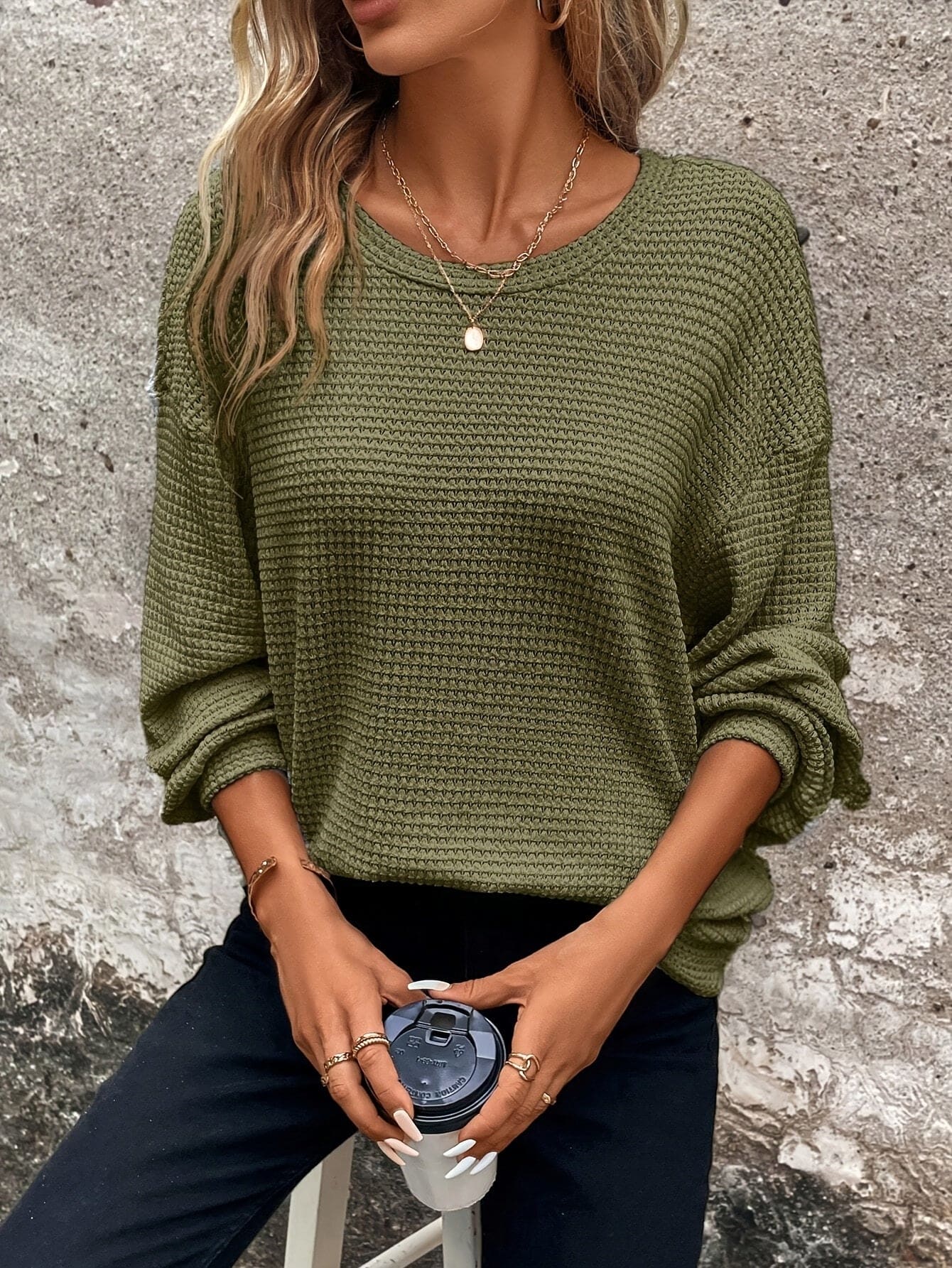Kvinde iført en afslappet sweatshirt med vaffelstrik og drop-shoulder pasform, stylet med mørke bukser_11