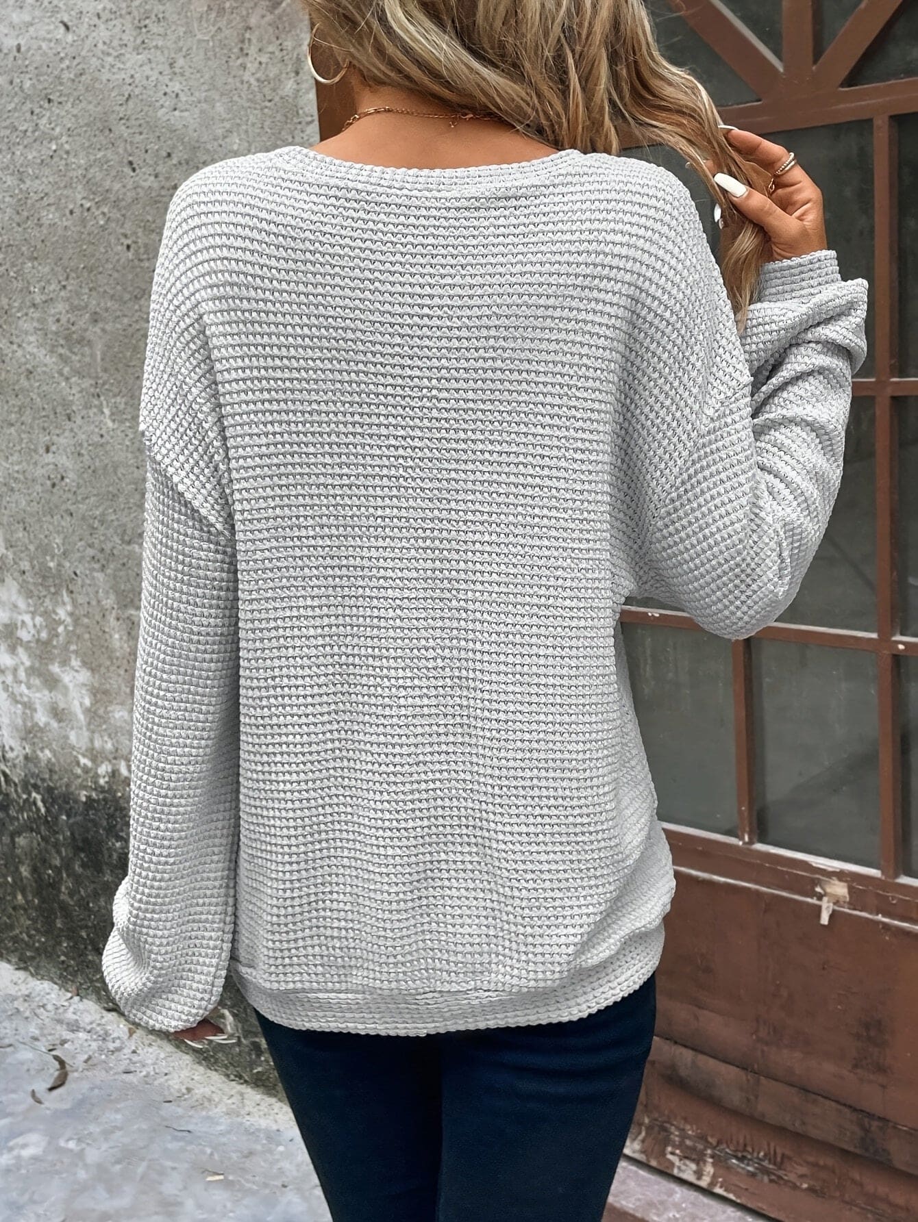 Kvinde iført en afslappet sweatshirt med vaffelstrik og drop-shoulder pasform, stylet med mørke bukser_2