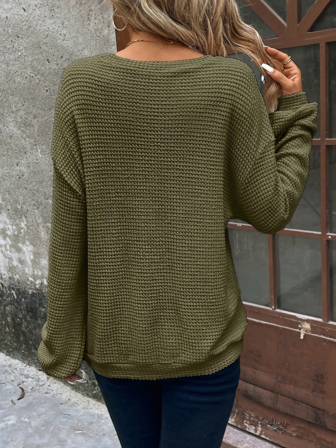 Kvinde iført en afslappet sweatshirt med vaffelstrik og drop-shoulder pasform, stylet med mørke bukser_8