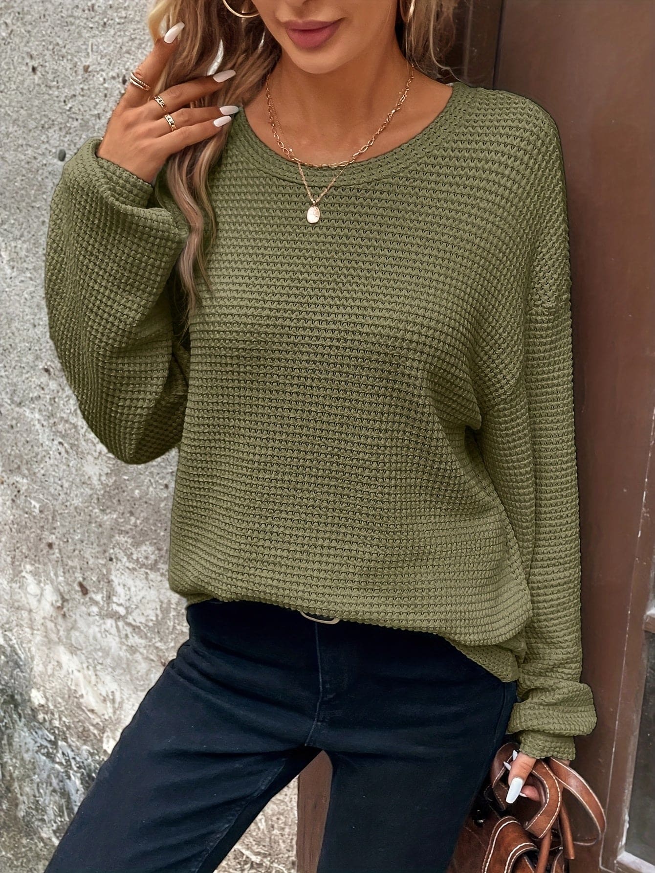 Kvinde iført en afslappet sweatshirt med vaffelstrik og drop-shoulder pasform, stylet med mørke bukser_9