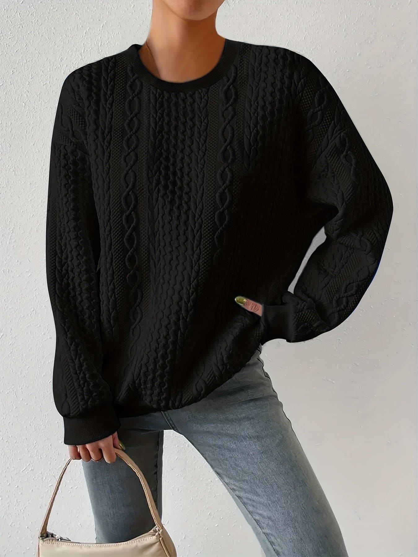 Hvid sweatshirt med struktureret kabelstriksmønster, fotograferet på model mod neutral baggrund._4