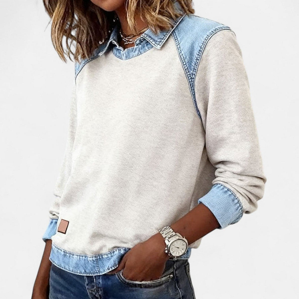 Kvinde iført beige sweatshirt med denimkrave og denimmanchetter, stylet med lysegrå denim_1