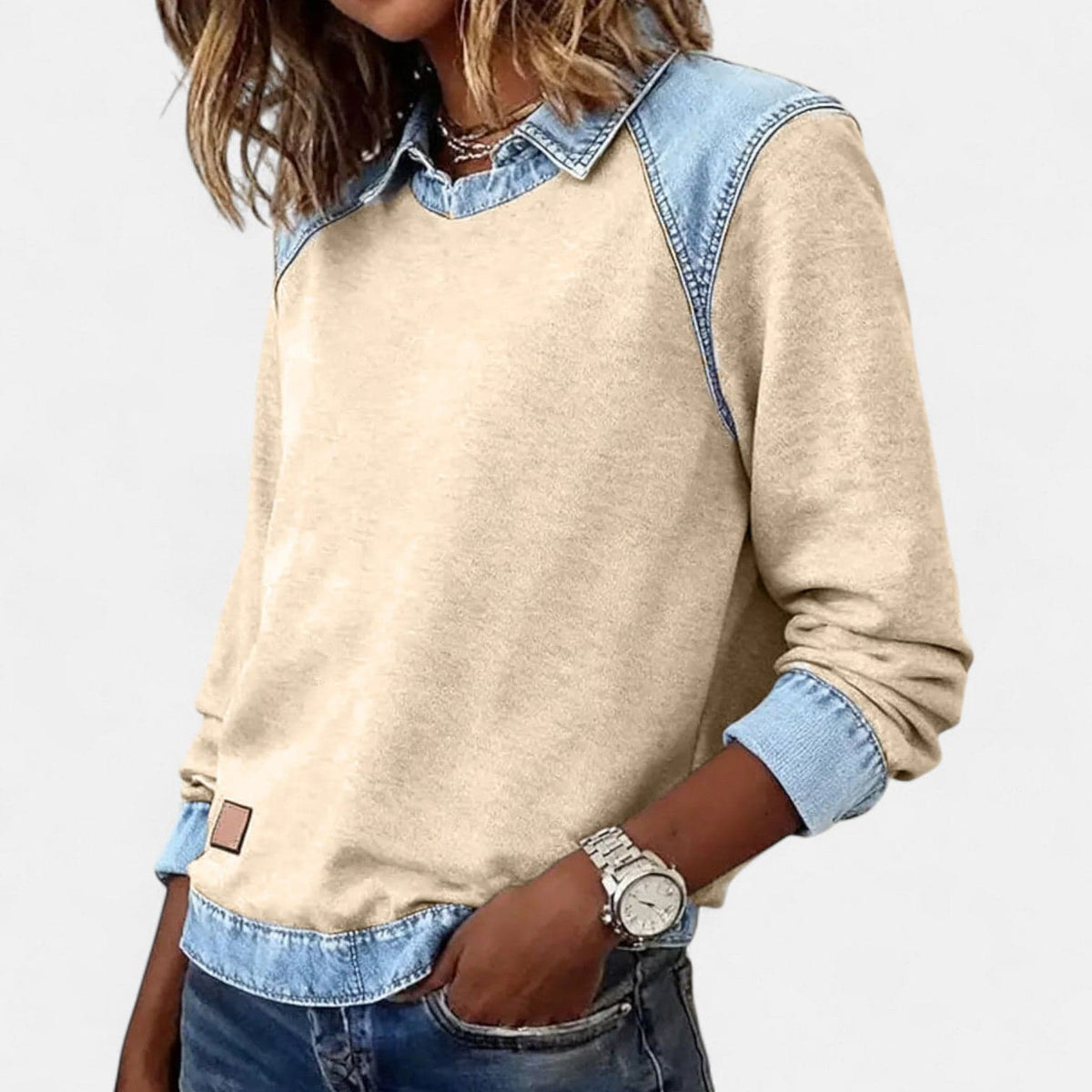 Kvinde iført beige sweatshirt med denimkrave og denimmanchetter, stylet med lysegrå denim_13
