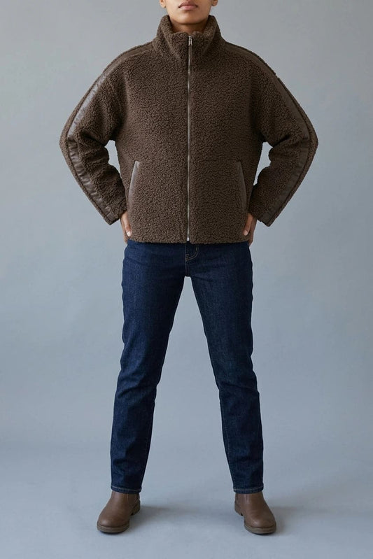 Kort teddyjakke med gennemgående lynlås, høj krave, glatte detaljer på ærmerne og to skrå lommer, styled med jeans og støvler._0