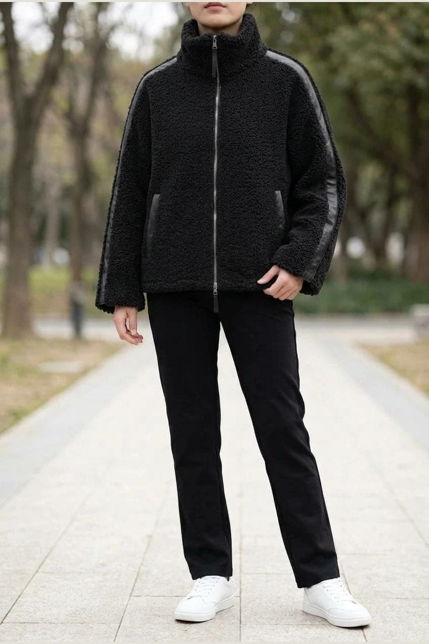 Kort teddyjakke med gennemgående lynlås, høj krave, glatte detaljer på ærmerne og to skrå lommer, styled med jeans og støvler._3