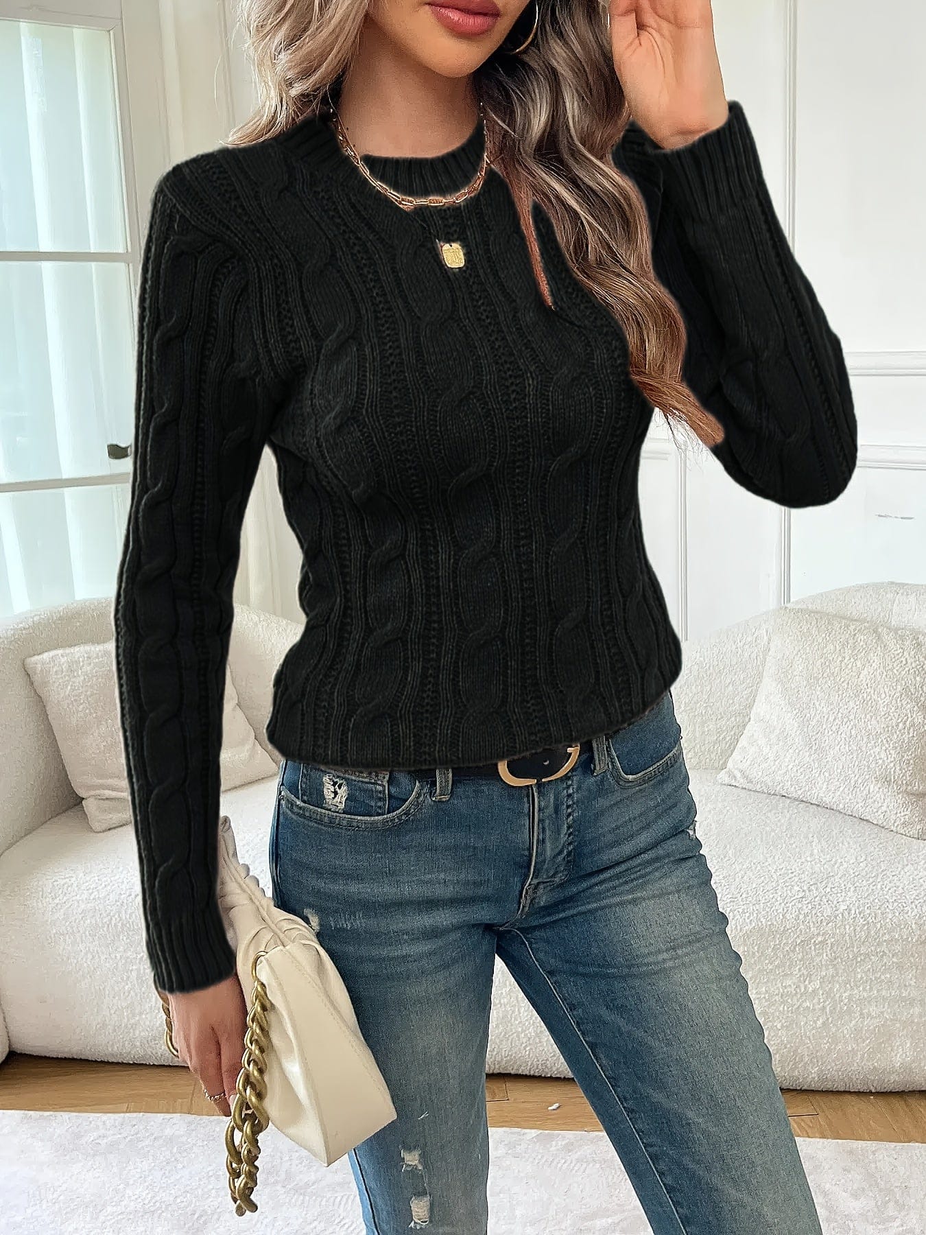 Kvinde iført tætsiddende twiststrikket sweater med rund hals og lange ærmer, stylet med jeans og guldsmykker_5