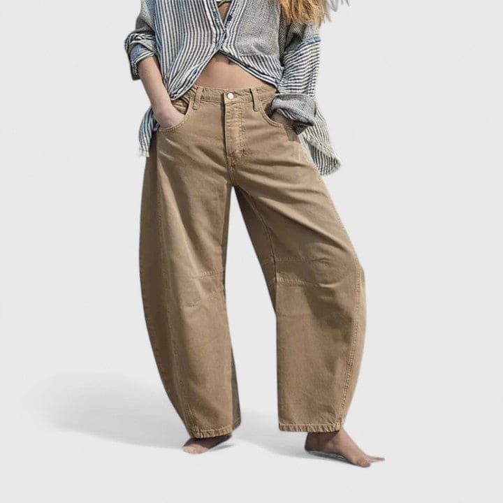 Kvinde iført vide jeans med høj talje og wide-leg pasform samt dekorative detaljer ved knæene, stylet med sorte espadrillos._13