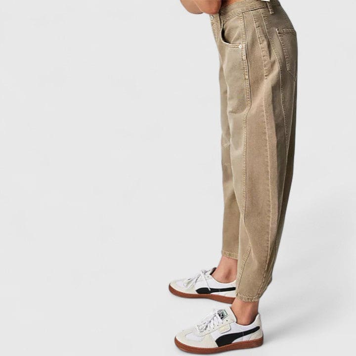 Kvinde iført vide jeans med høj talje og wide-leg pasform samt dekorative detaljer ved knæene, stylet med sorte espadrillos._14