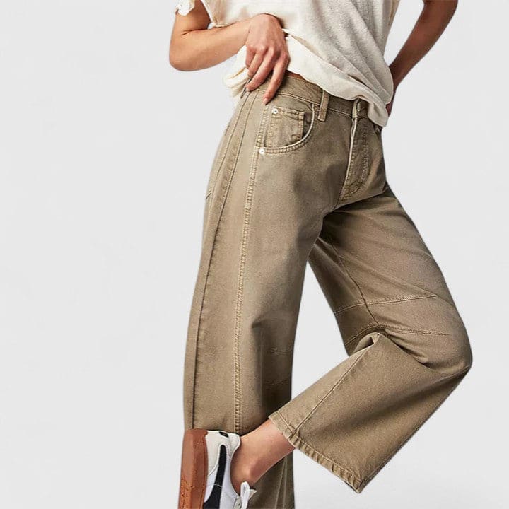 Kvinde iført vide jeans med høj talje og wide-leg pasform samt dekorative detaljer ved knæene, stylet med sorte espadrillos._15