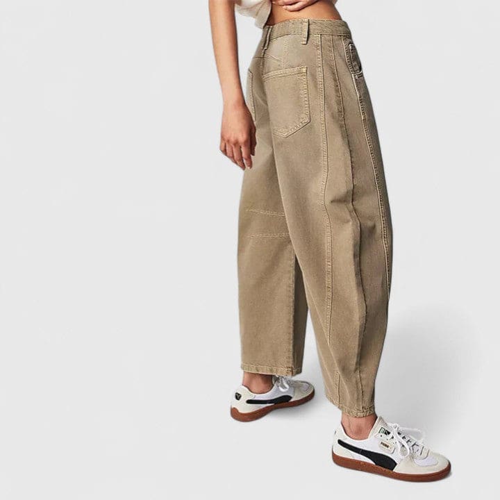Kvinde iført vide jeans med høj talje og wide-leg pasform samt dekorative detaljer ved knæene, stylet med sorte espadrillos._16