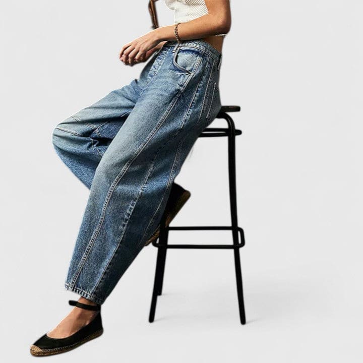 Kvinde iført vide jeans med høj talje og wide-leg pasform samt dekorative detaljer ved knæene, stylet med sorte espadrillos._17