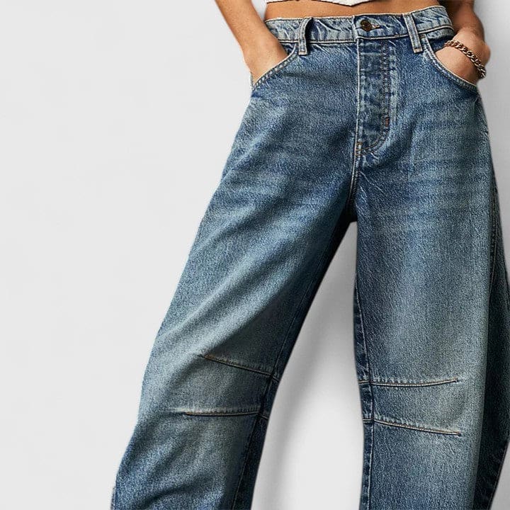 Kvinde iført vide jeans med høj talje og wide-leg pasform samt dekorative detaljer ved knæene, stylet med sorte espadrillos._18
