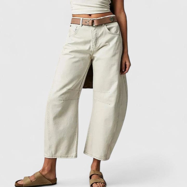 Kvinde iført vide jeans med høj talje og wide-leg pasform samt dekorative detaljer ved knæene, stylet med sorte espadrillos._2