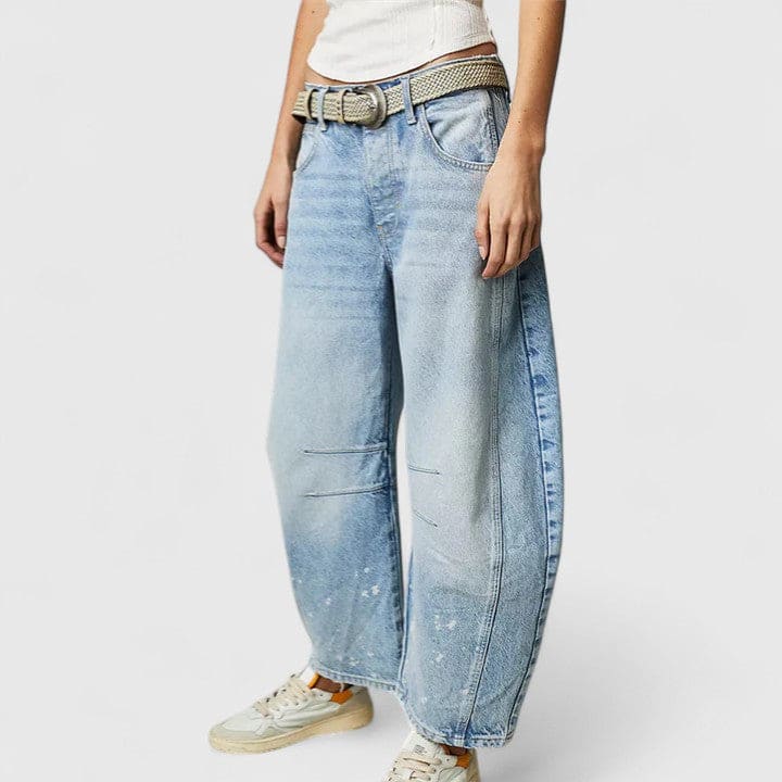 Kvinde iført vide jeans med høj talje og wide-leg pasform samt dekorative detaljer ved knæene, stylet med sorte espadrillos._20