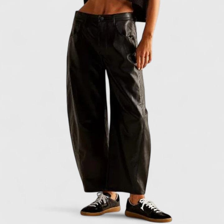 Kvinde iført vide jeans med høj talje og wide-leg pasform samt dekorative detaljer ved knæene, stylet med sorte espadrillos._22