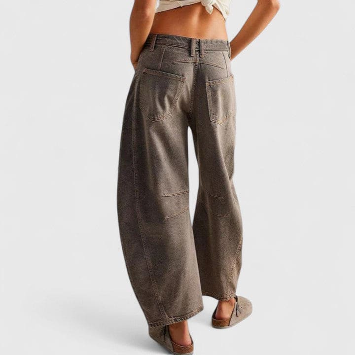 Kvinde iført vide jeans med høj talje og wide-leg pasform samt dekorative detaljer ved knæene, stylet med sorte espadrillos._23