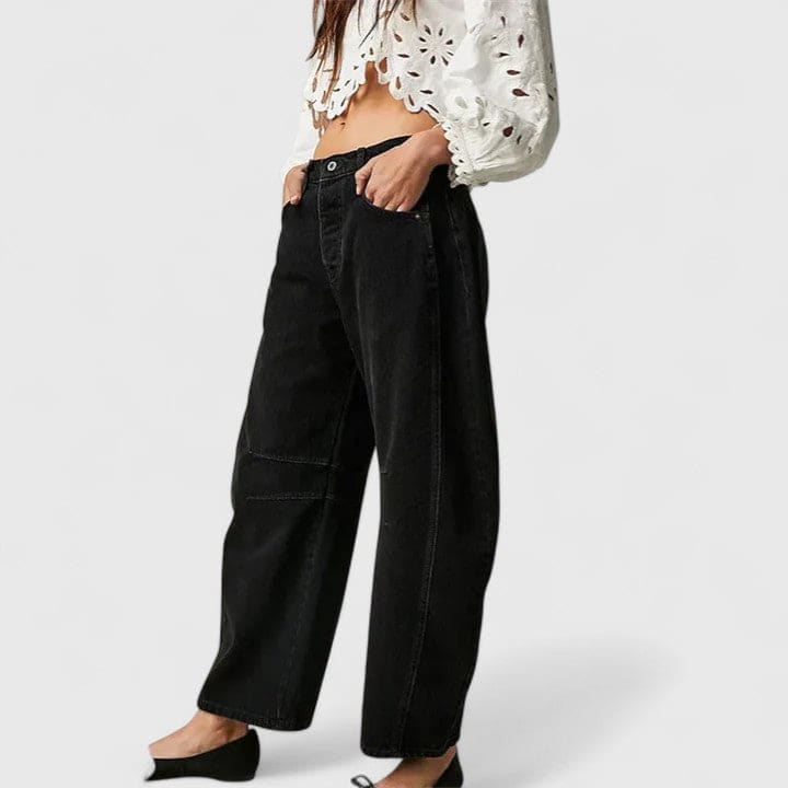 Kvinde iført vide jeans med høj talje og wide-leg pasform samt dekorative detaljer ved knæene, stylet med sorte espadrillos._26