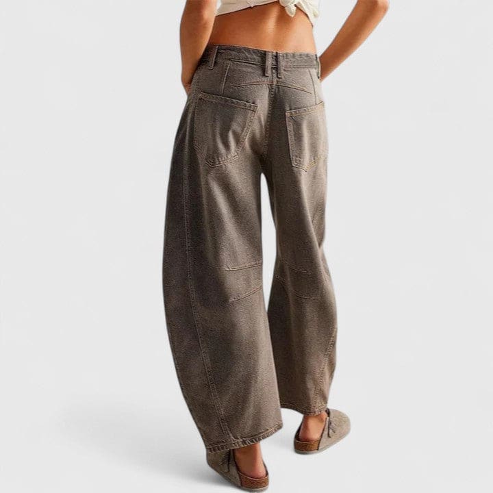 Kvinde iført vide jeans med høj talje og wide-leg pasform samt dekorative detaljer ved knæene, stylet med sorte espadrillos._27