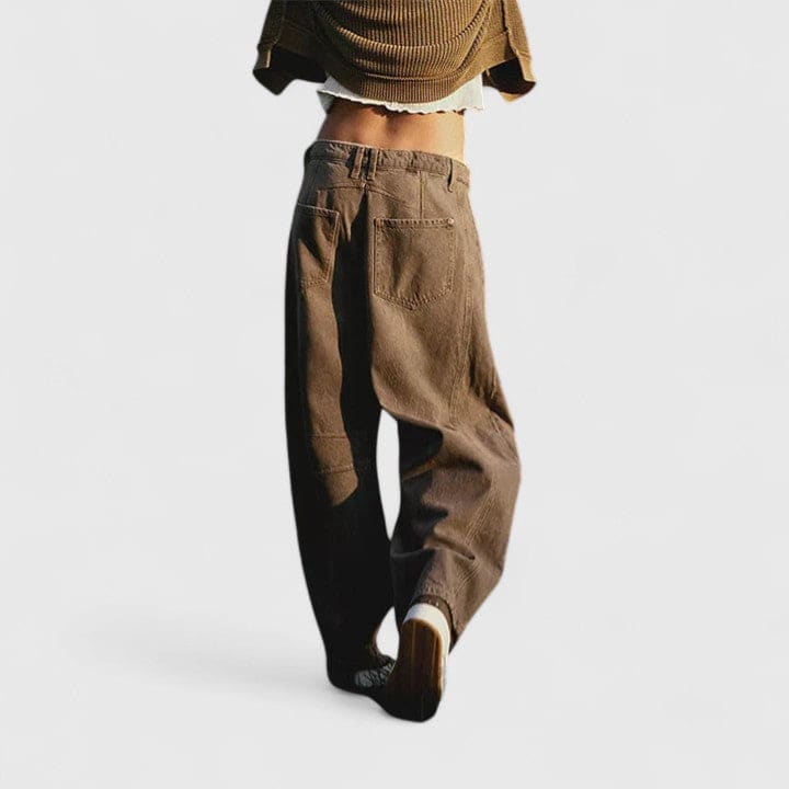 Kvinde iført vide jeans med høj talje og wide-leg pasform samt dekorative detaljer ved knæene, stylet med sorte espadrillos._5