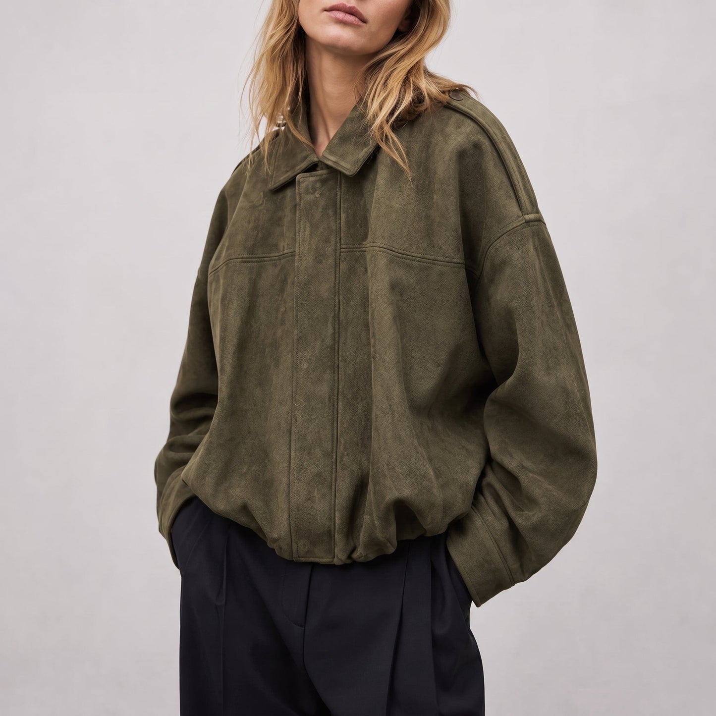Kvinde iført en oversized vintage bomberjacke i olivengrøn med klassisk krave, afsatte skuldre og elastisk kant ved hoften._0