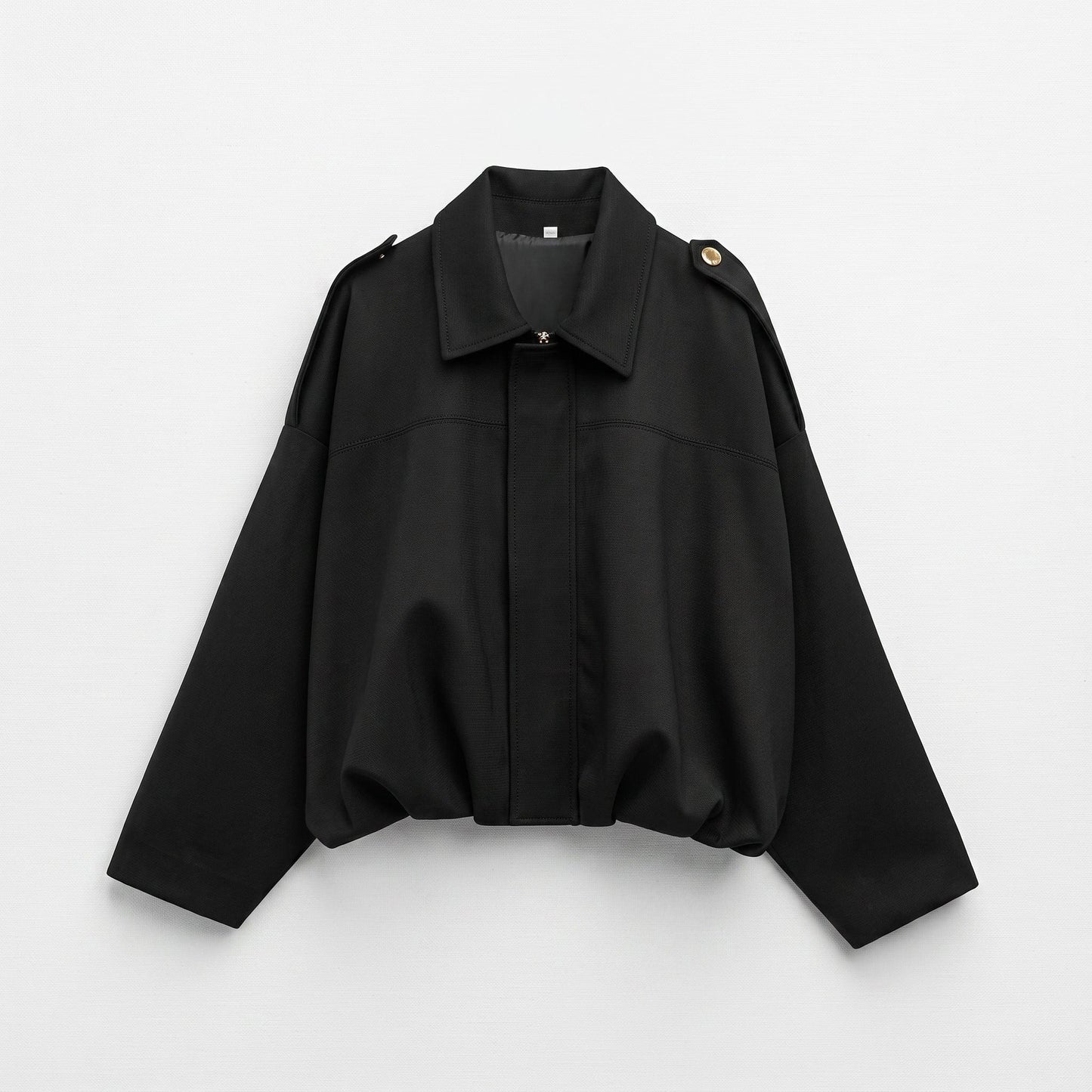 Kvinde iført en oversized vintage bomberjacke i olivengrøn med klassisk krave, afsatte skuldre og elastisk kant ved hoften._9