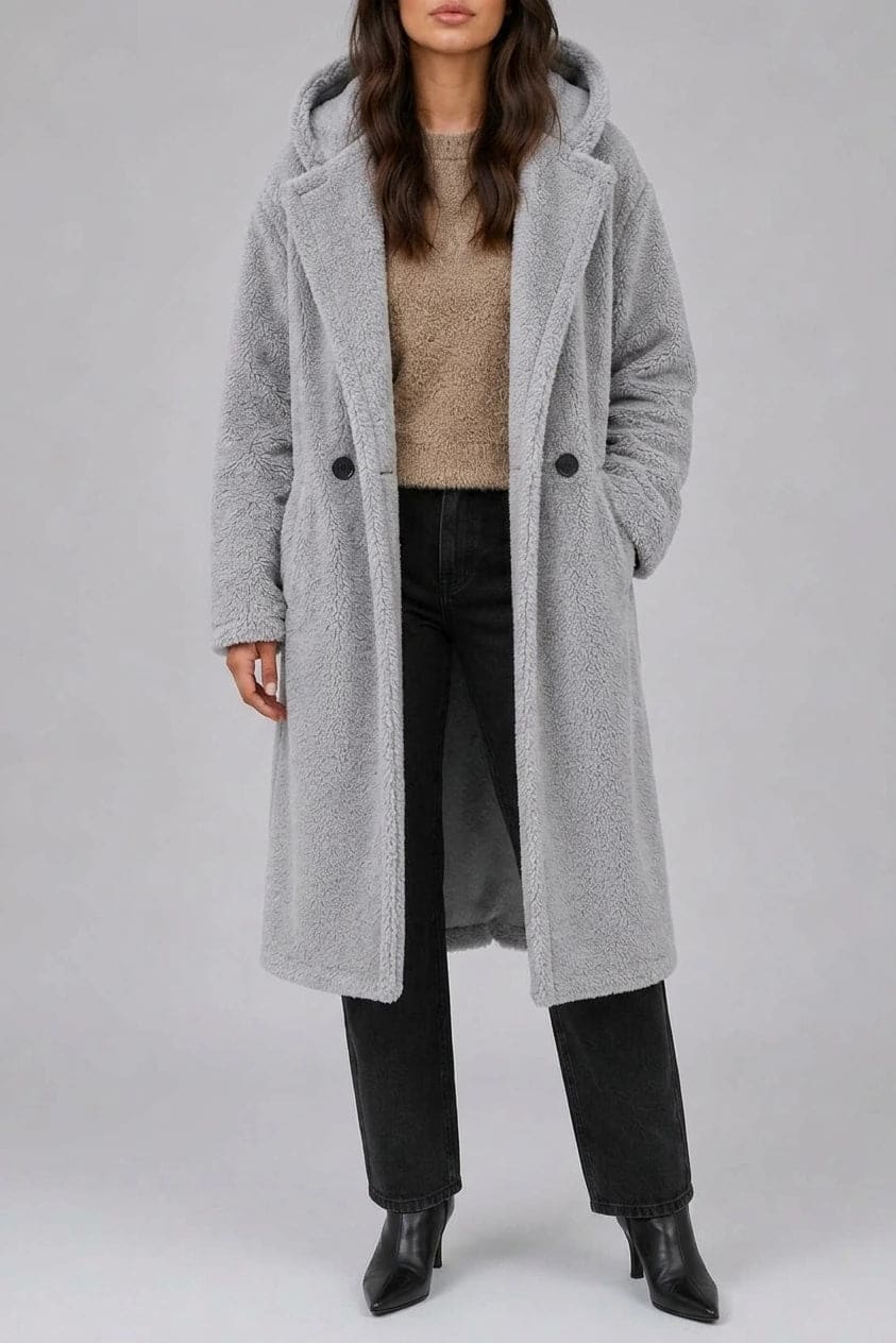 Lang teddyfrakke med hætte, brede revers, to knapper foran og sidelommer, styles med jeans og ankelstøvler._0