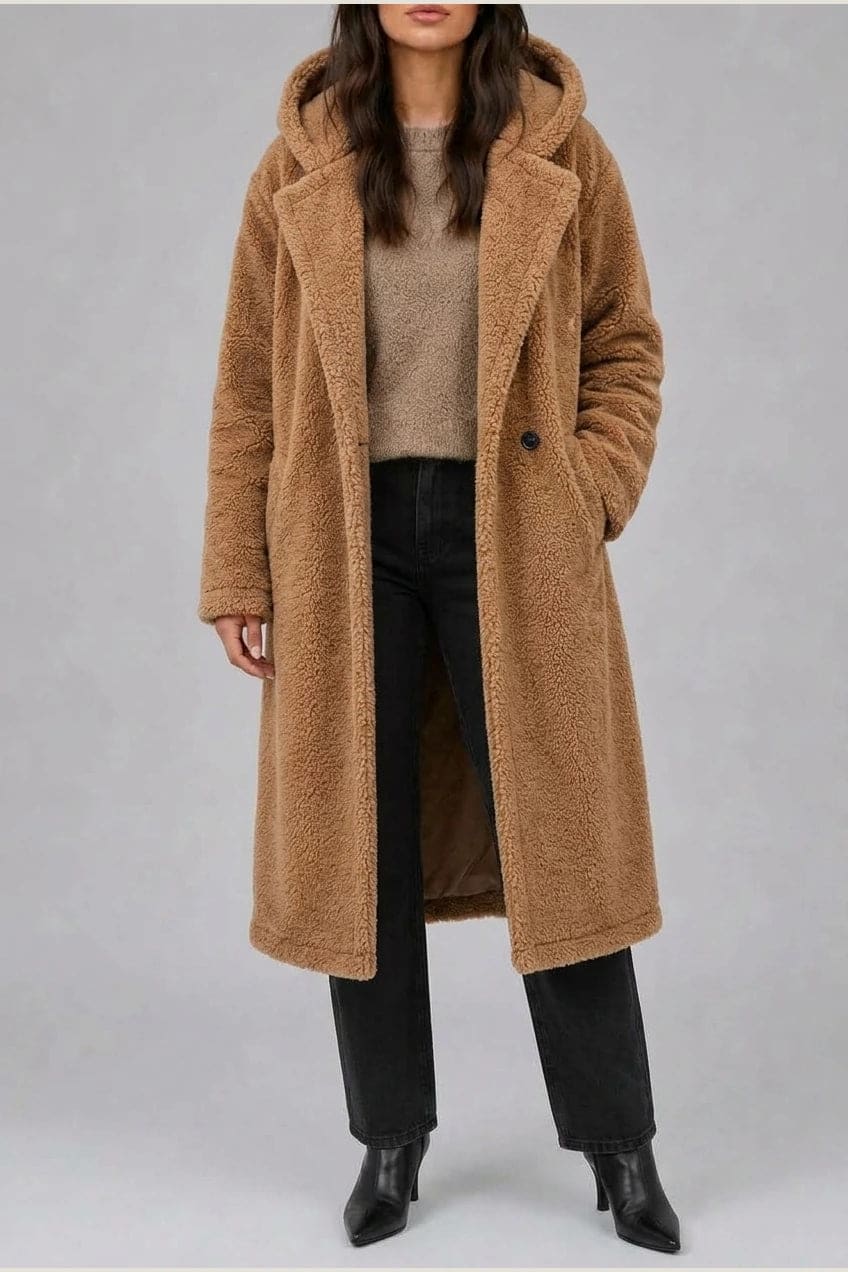 Lang teddyfrakke med hætte, brede revers, to knapper foran og sidelommer, styles med jeans og ankelstøvler._1