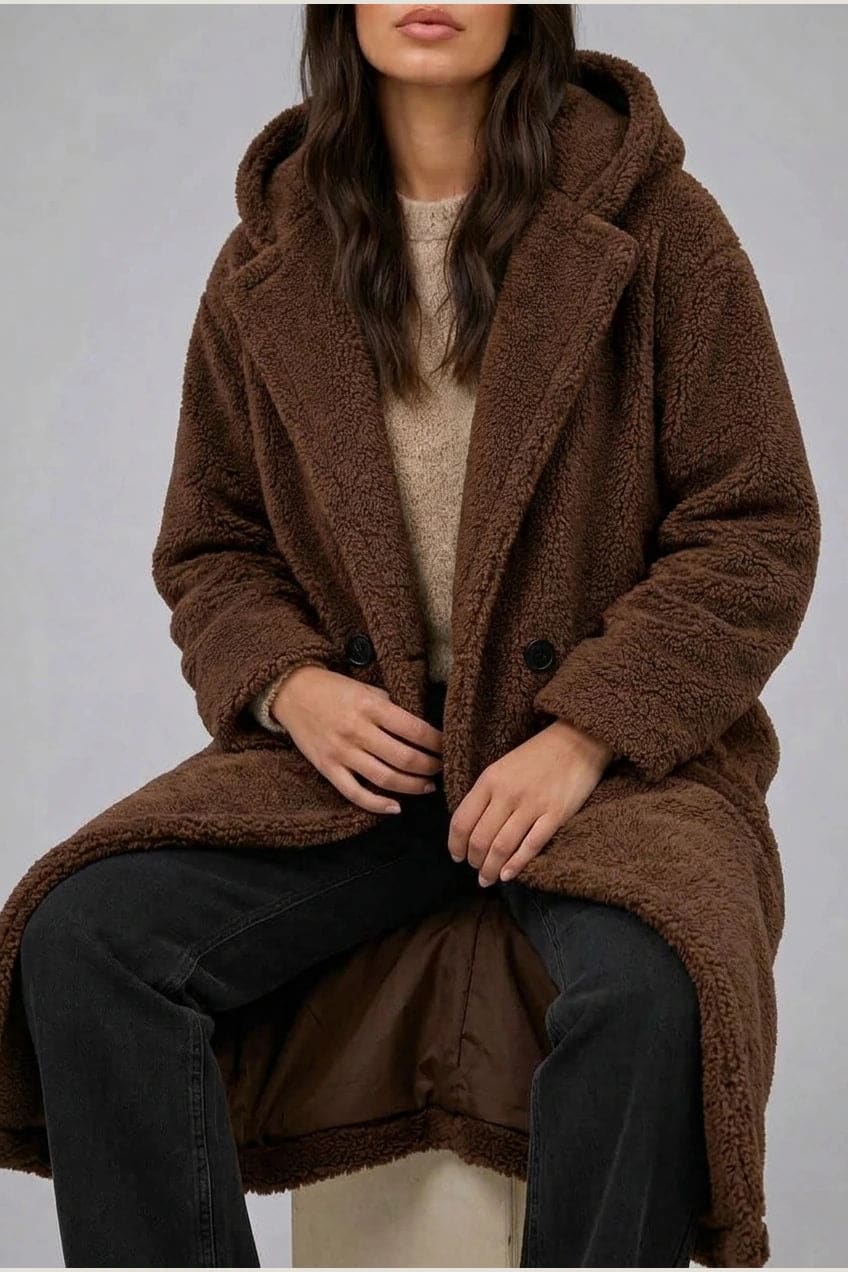 Lang teddyfrakke med hætte, brede revers, to knapper foran og sidelommer, styles med jeans og ankelstøvler._10