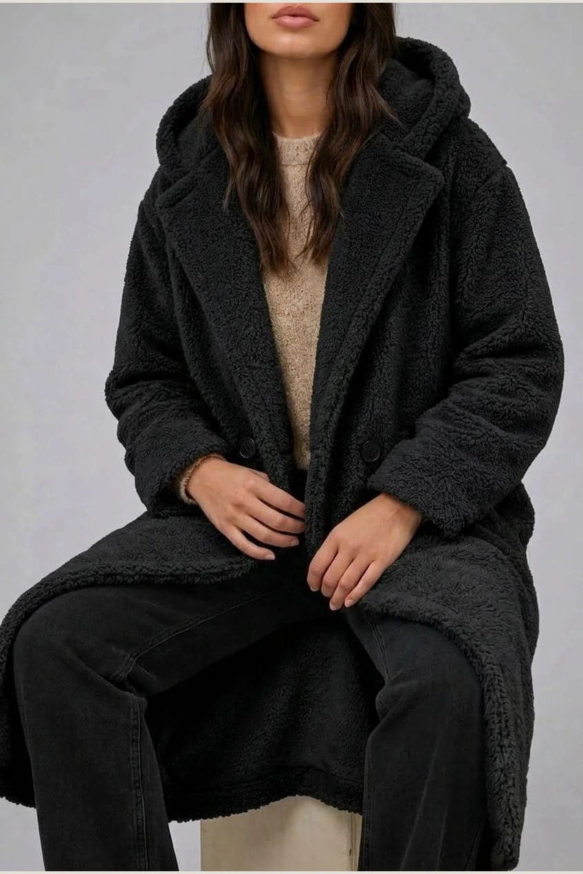 Lang teddyfrakke med hætte, brede revers, to knapper foran og sidelommer, styles med jeans og ankelstøvler._16